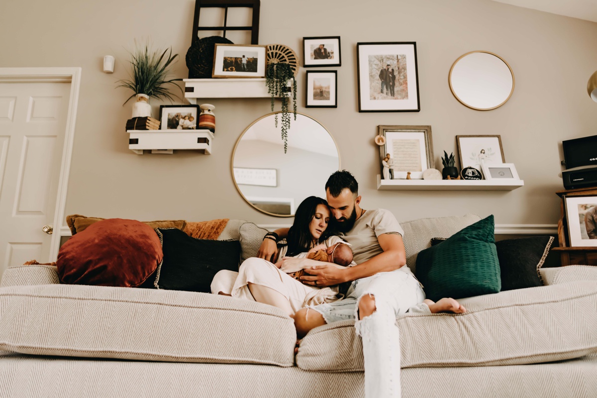 family of 3 in home photo session with newborn baby