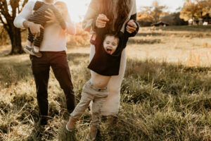 Little boy being swung by his dad at a family photo session in Marietta, Ga.