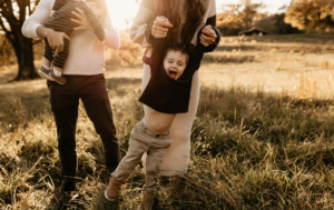 little boy being swung by his dad during family photos in Marietta, Ga.