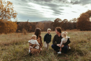 family posing for family photos at sunset in the fall in GA